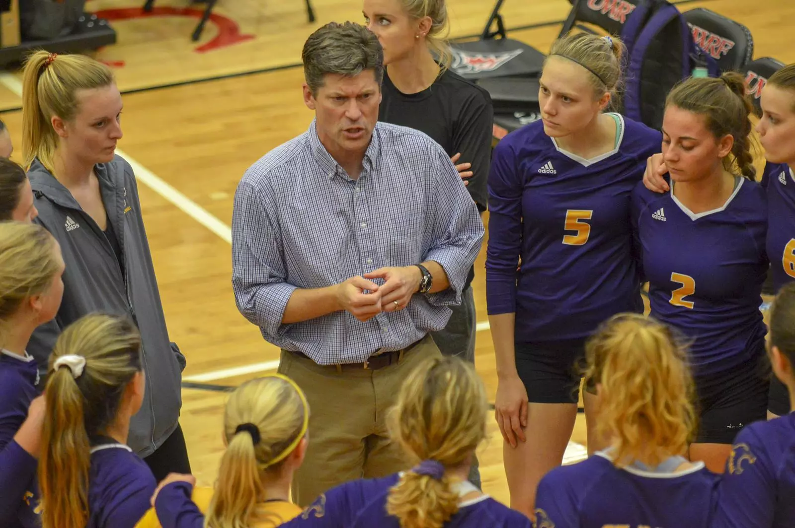 Volleyball Head Coach Todd Nelson with team at UW River Falls Tournament in Huddle