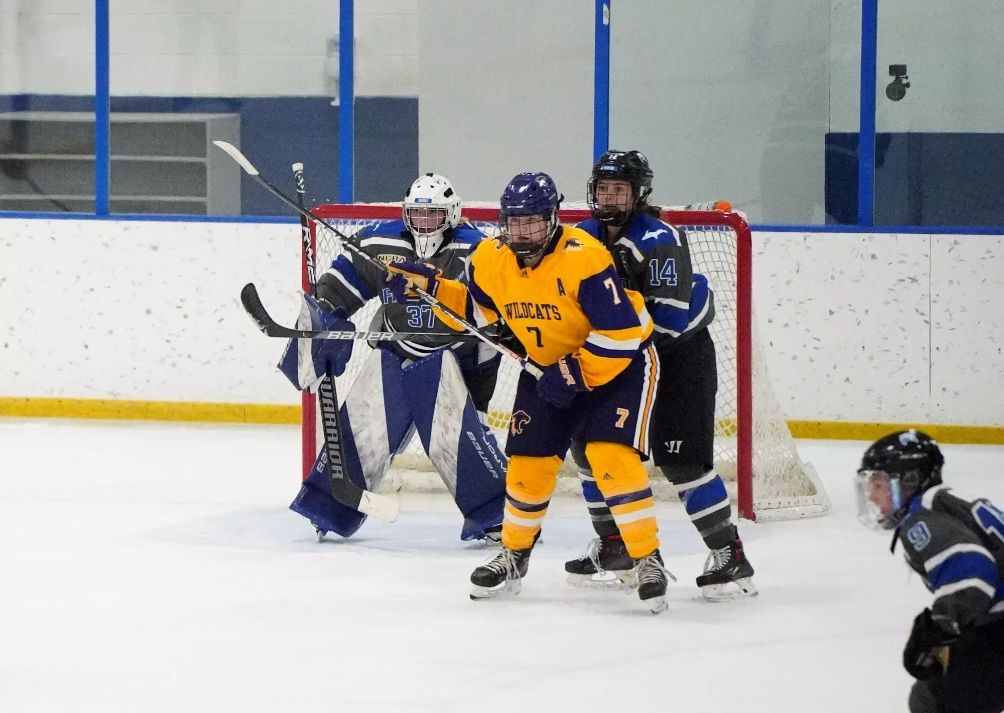 Marie Reimer infront of net surrounded by Finlandia Players