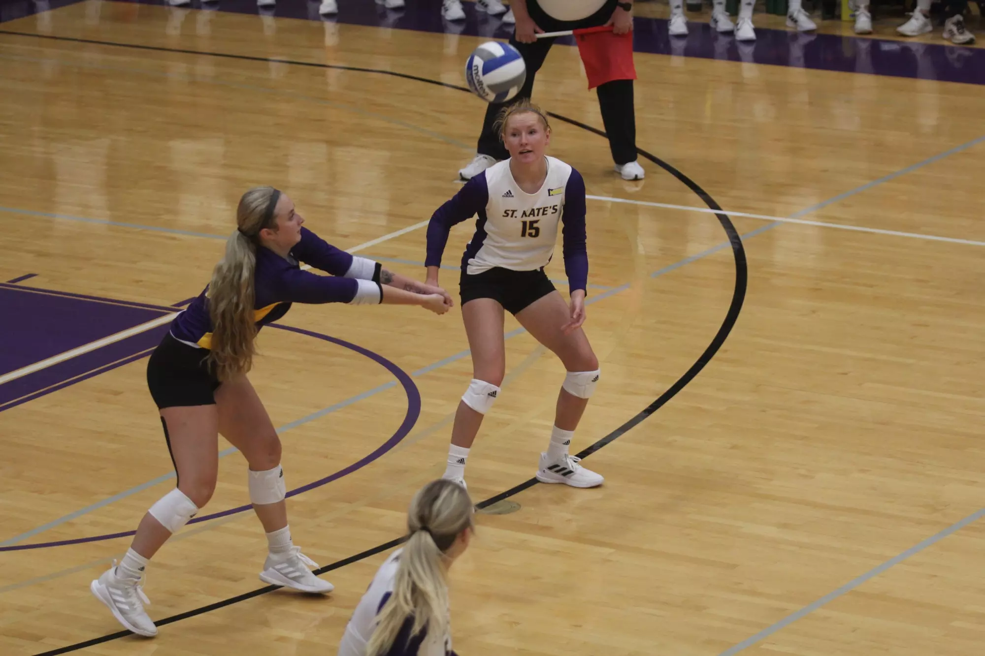 Claire Segner digging ball with Brenna Essig in the background