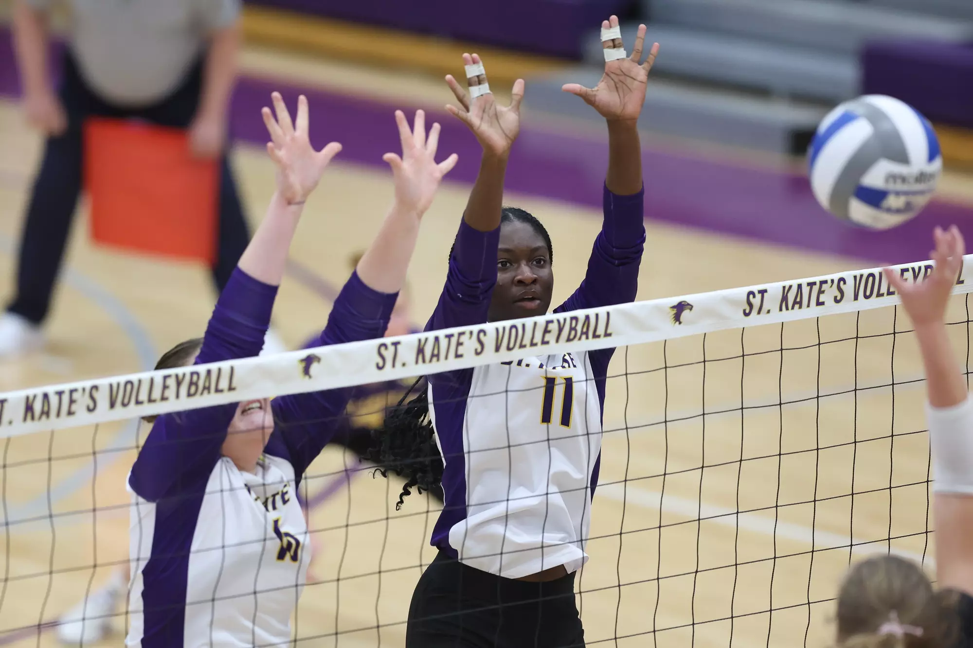 Eleanor Erickson and Madison Fagan at the net blocking