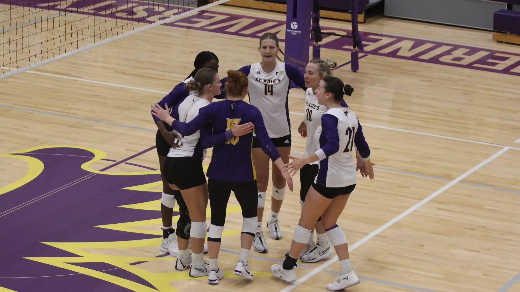 volleyball team huddle at Butler Center