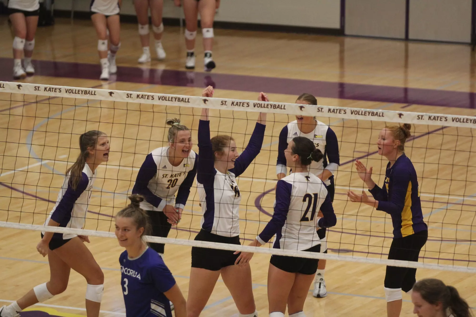 St. Catherine Volleyball team celebrating in butler center