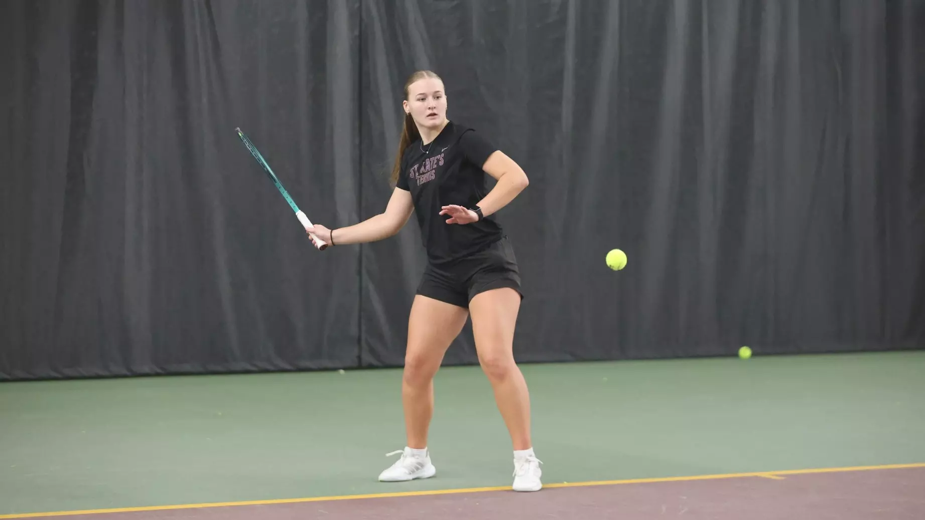 Ashley King hitting tennis ball at Baseline Tennis Center